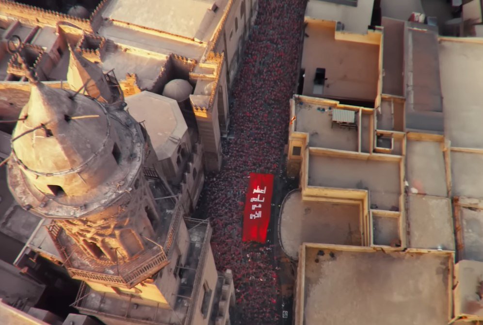 Final film frame — aerial of the crowd and banner