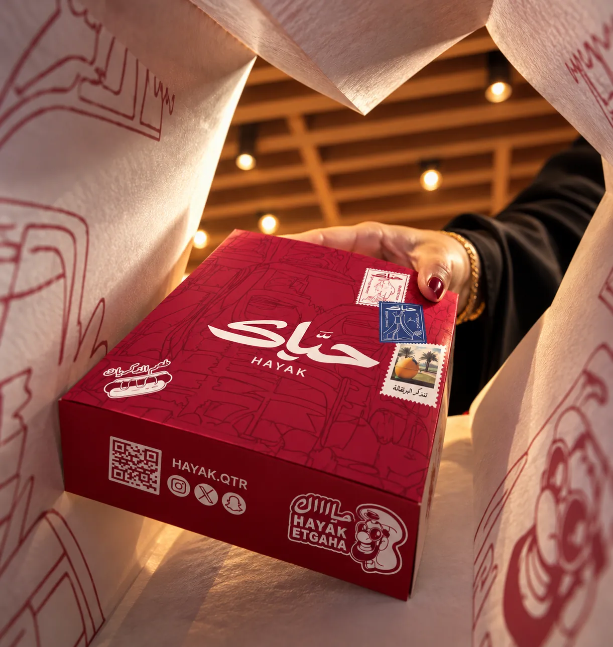 A red Hayak box inside a bag printed with the doodle pattern