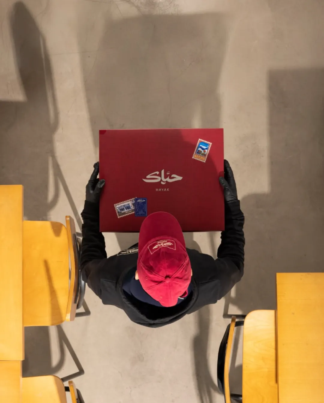 A Hayak delivery rider carrying the red box, seen from above