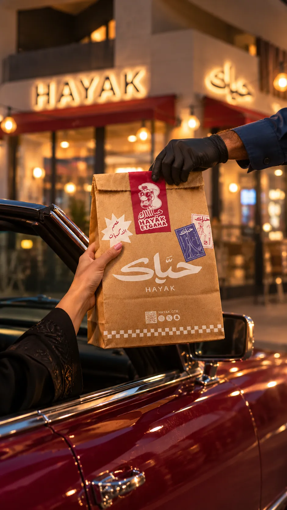 A Hayak kraft bag handed through a car window outside the store at dusk